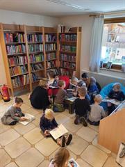 Eine Gruppe von Kindern sitzt in einer Bibliothek